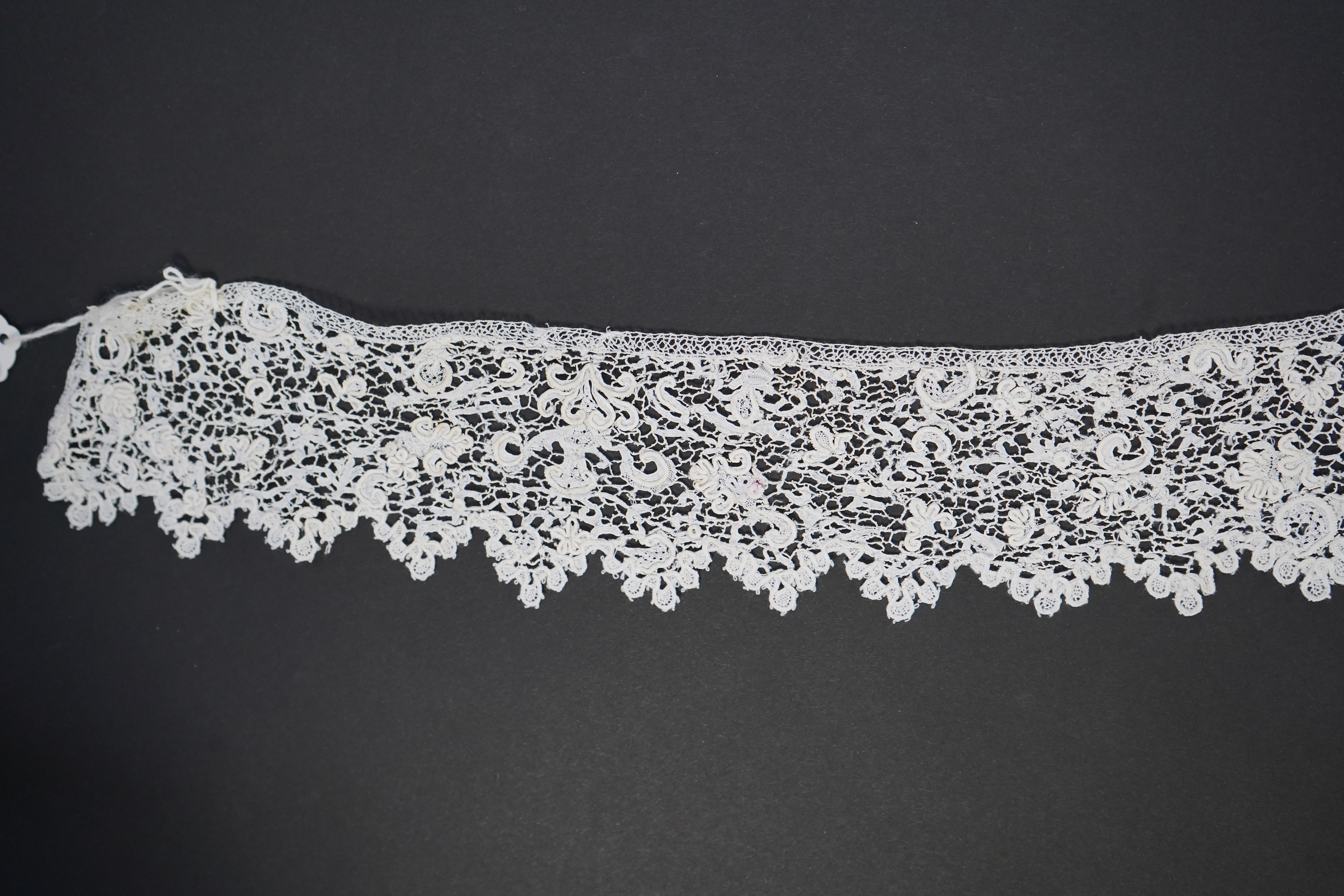 A late 17th century wide flounce of Point de France needle lace, together with a narrower flounce, both with raised elements of the design in the style of Point de Rose, but less so. This lace was very popular with the F